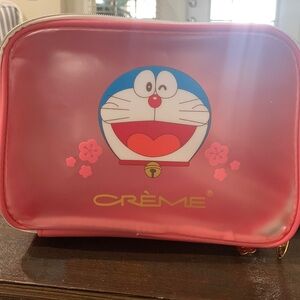 Embracing good fortune with crème shop.        Doraemon Lucy Lunar Travel Case
